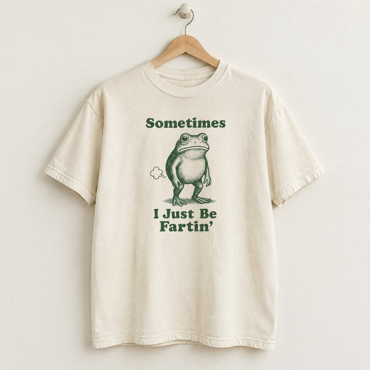 Ivory Comfort Colors shirt on a hanger with Sometimes I Just Be Fartin frog design