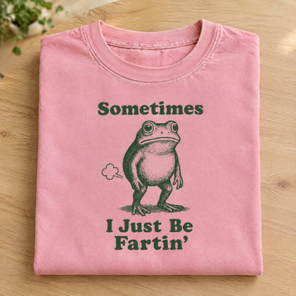 Folded Blossom pink Comfort Colors tee with Sometimes I Just Be Fartin frog print