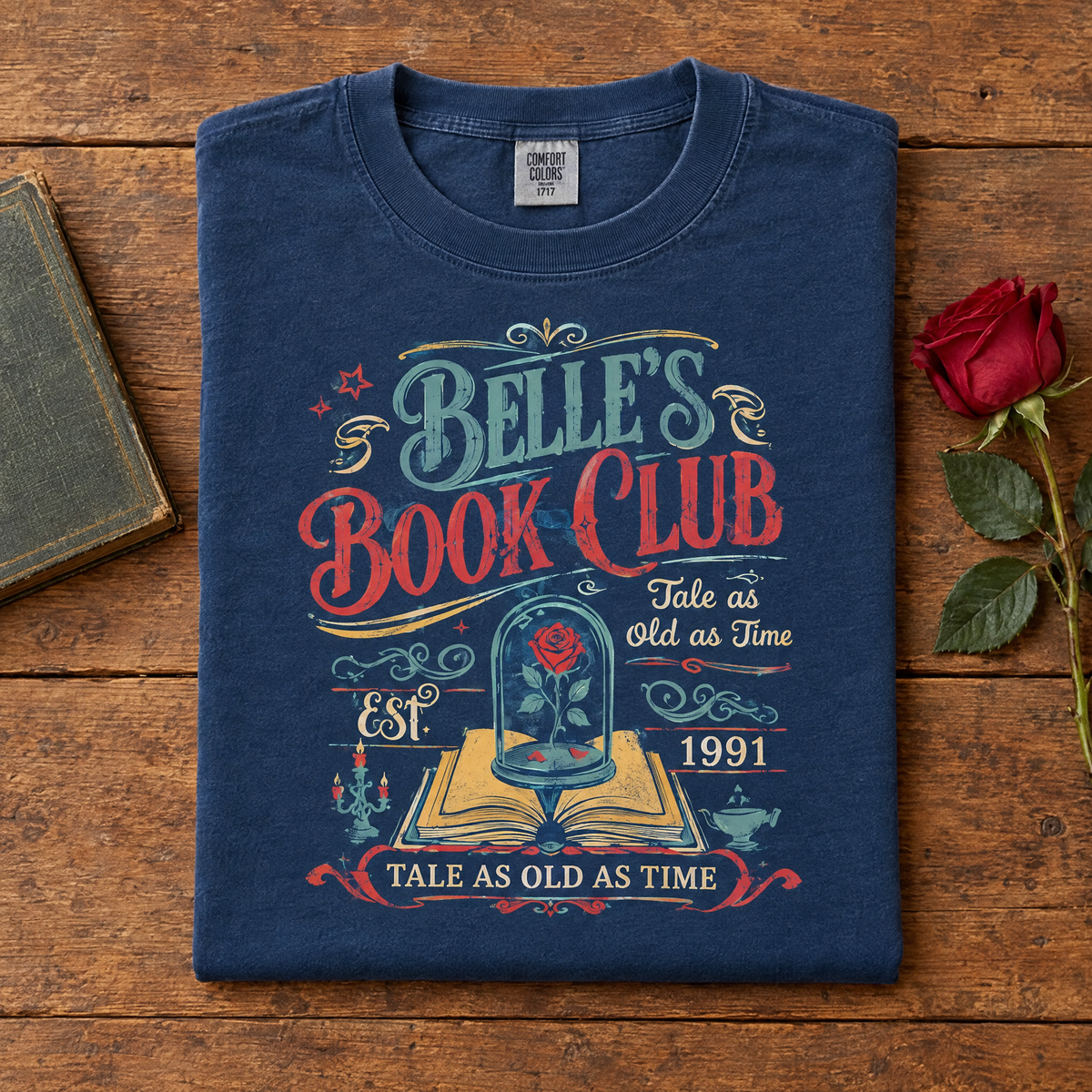 Tale as old as time bookish tee in Navy, folded with a vintage book and a red rose