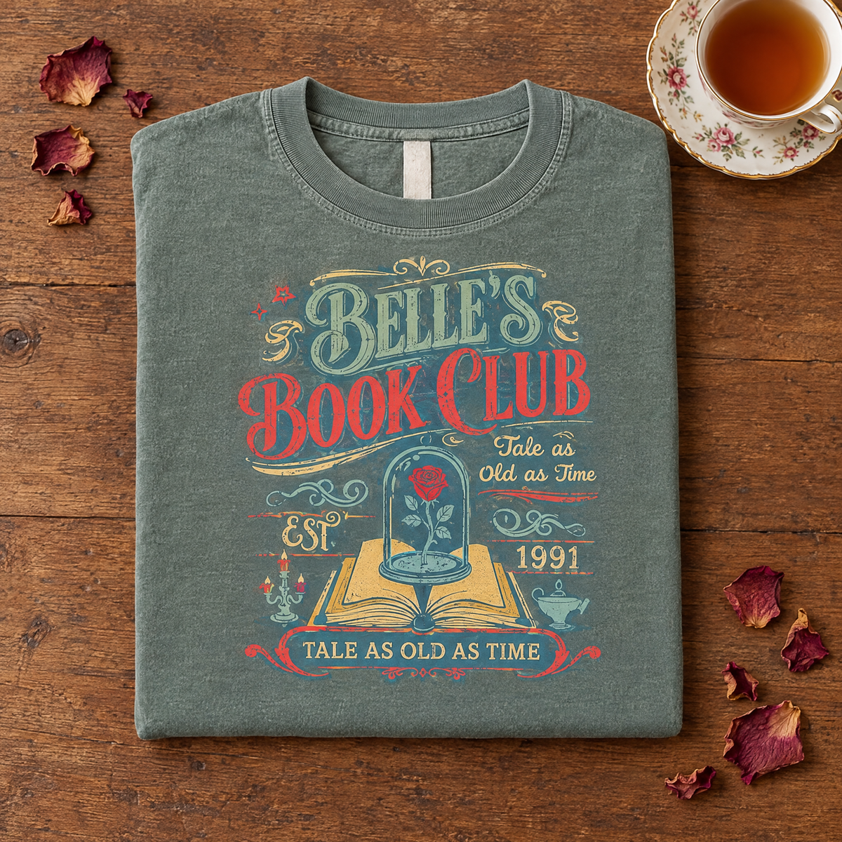 Bookish rose tee in Sage, folded with a teacup and rose petals