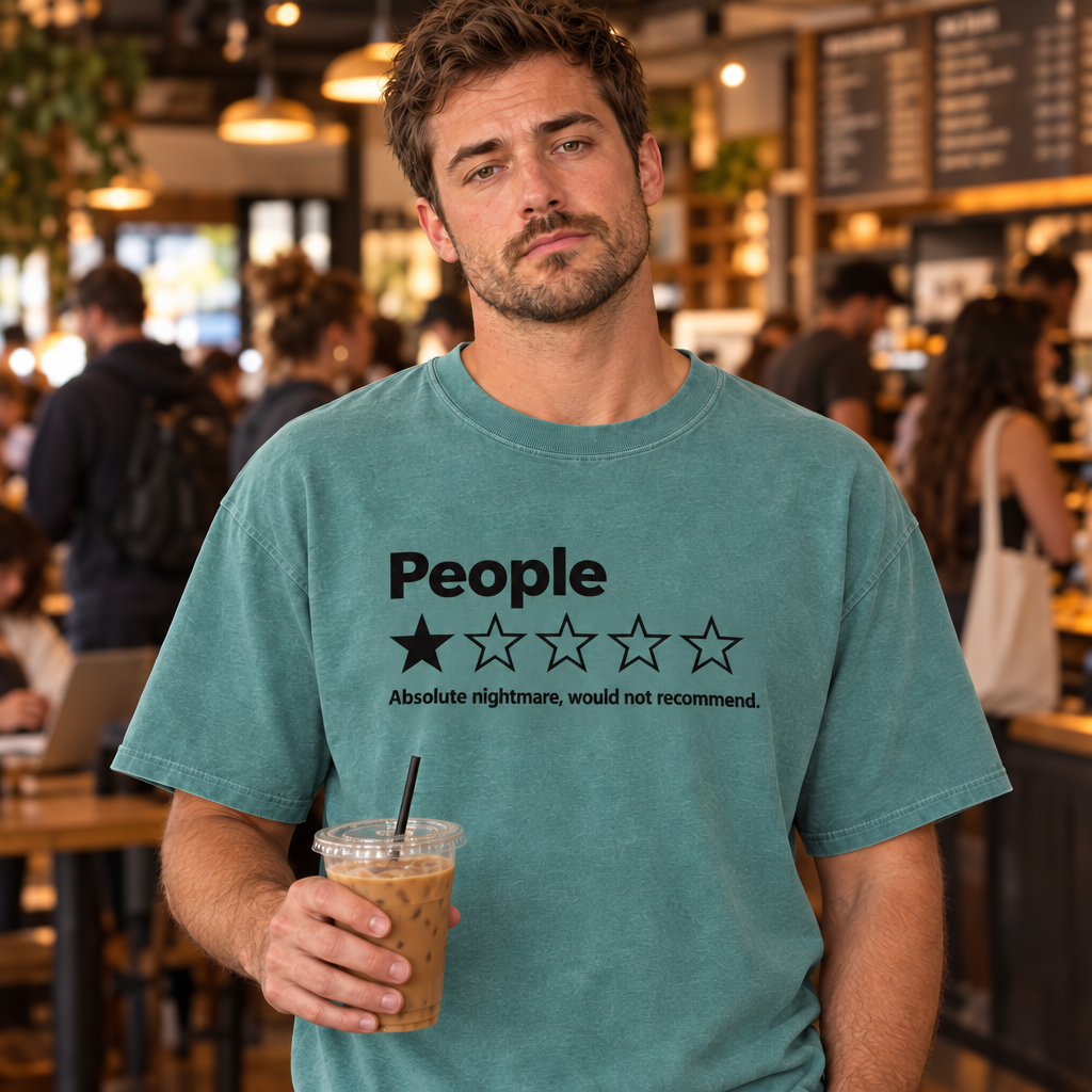 Man wearing Seafoam Comfort Colors one star review funny introvert shirt in a busy coffee shop