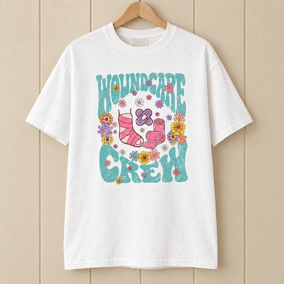 Wound Care Crew Comfort Colors shirt in White on a wooden hanger