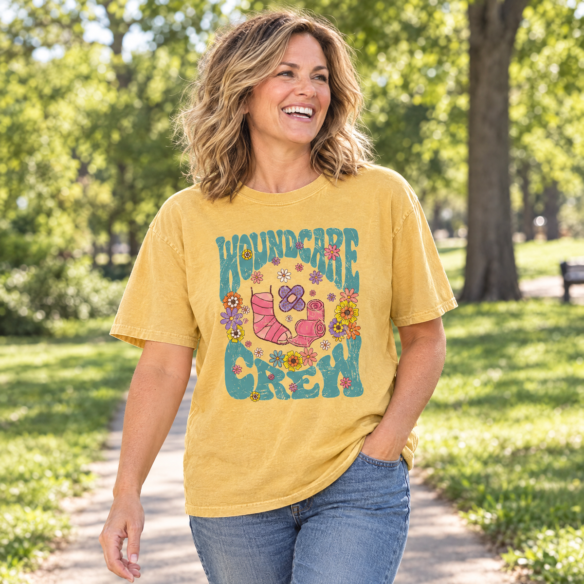 Woman wearing a Mustard Comfort Colors Wound Care Crew shirt walking in a sunny park