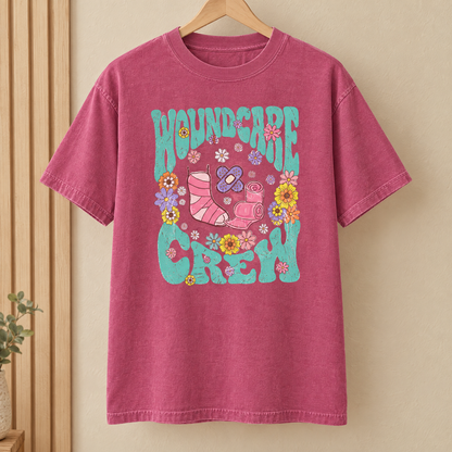 Wound Care Crew Comfort Colors shirt in Berry on a wooden hanger