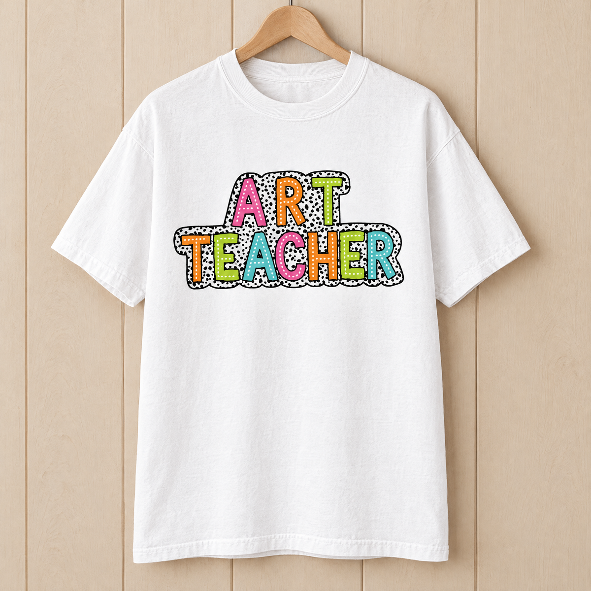 Art Teacher Comfort Colors shirt in White on a wooden hanger