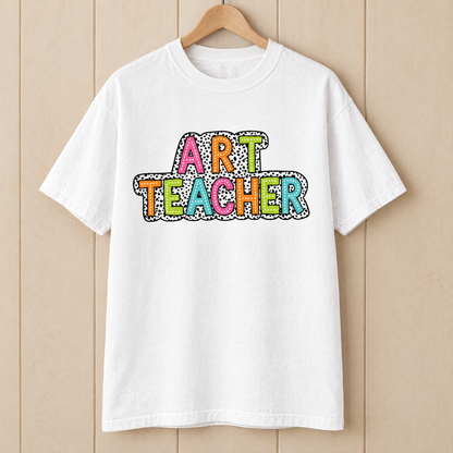 Art Teacher Comfort Colors shirt in White on a wooden hanger