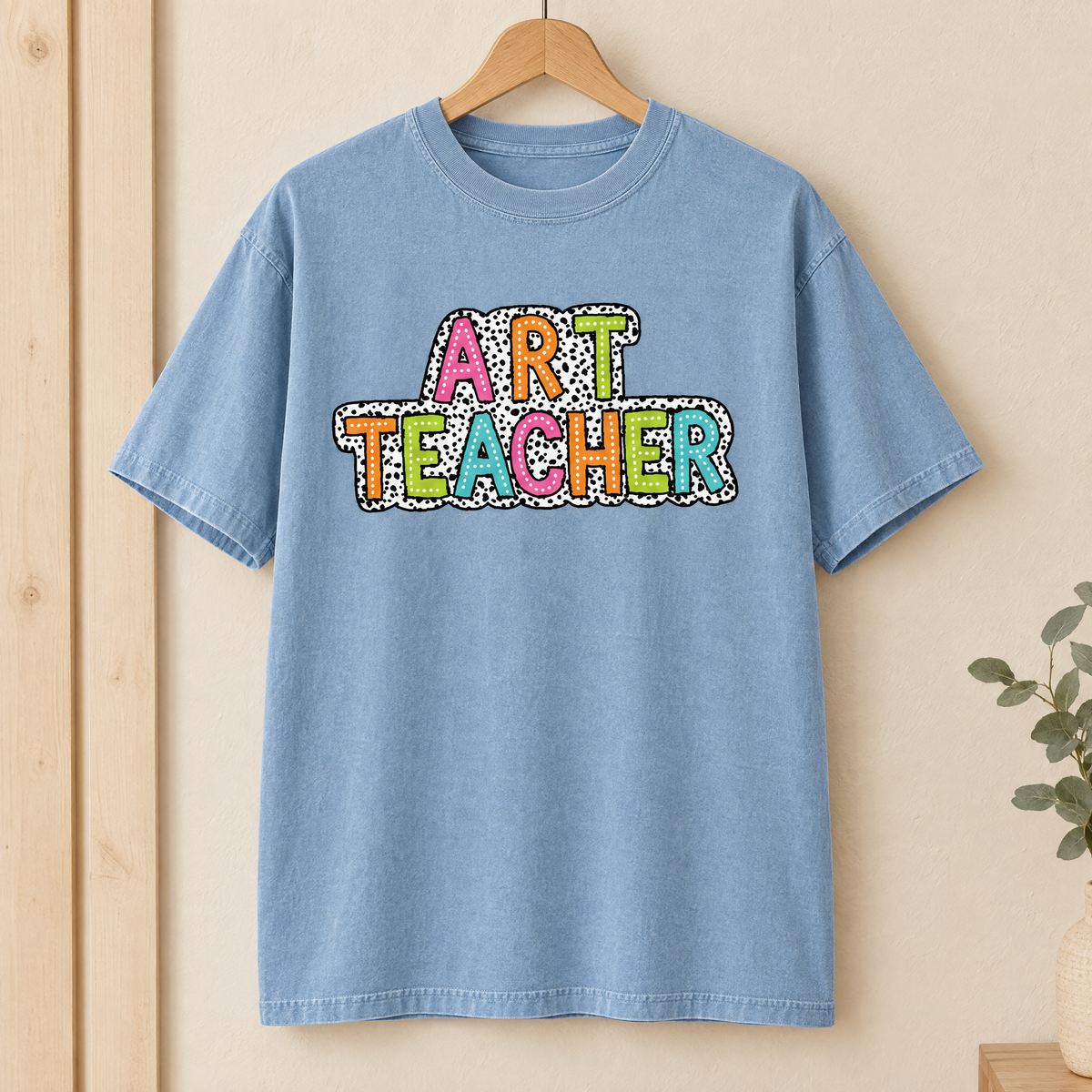 Art Teacher Comfort Colors shirt in Chambray on a wooden hanger