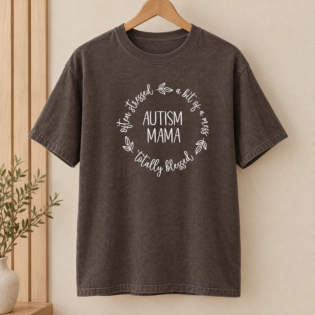 Autism Mama Comfort Colors shirt in Espresso on a wooden hanger