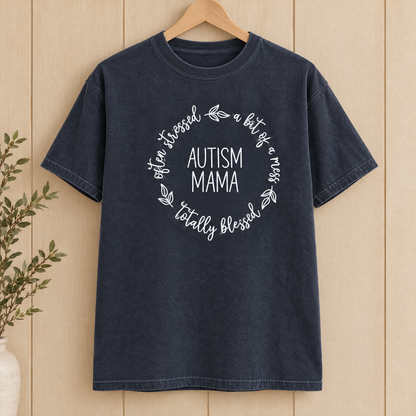 Autism Mama Comfort Colors shirt in Midnight on a wooden hanger