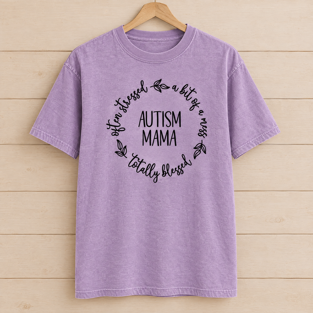 Autism Mama Comfort Colors shirt in Orchid on a wooden hanger