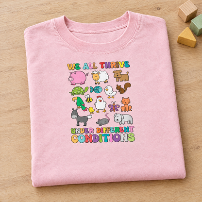 We All Thrive Under Different Conditions Comfort Colors tee in Blossom pink, neatly folded