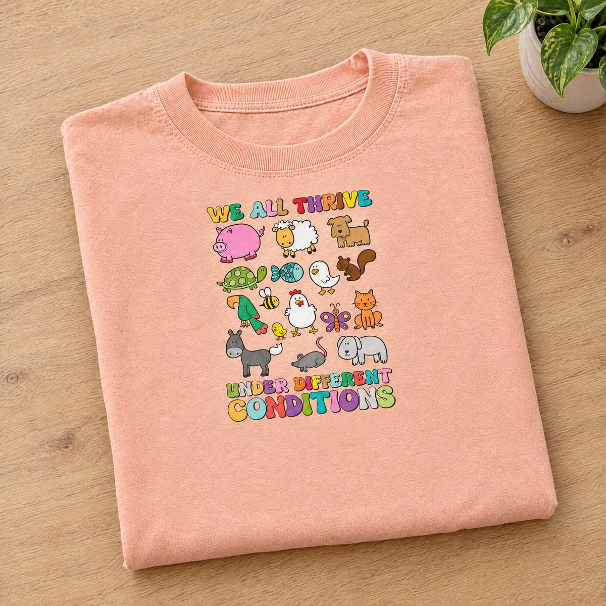 We All Thrive Under Different Conditions Comfort Colors tee in Peachy, neatly folded