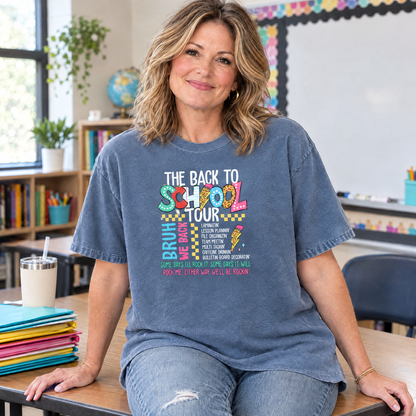 Teacher wearing a Blue Jean Comfort Colors Back to School Tour shirt sitting on a classroom desk