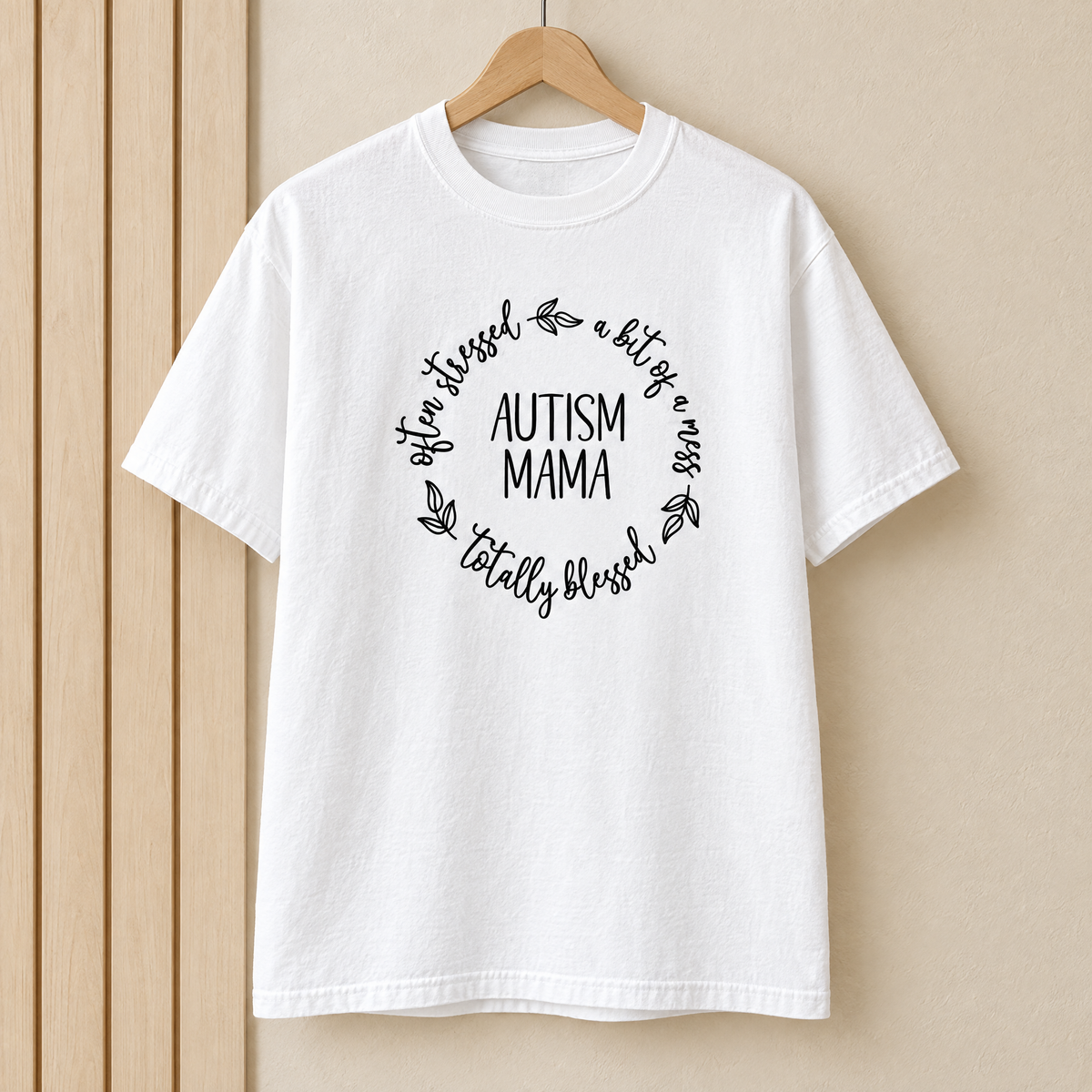 Autism Mama Comfort Colors shirt in White on a wooden hanger