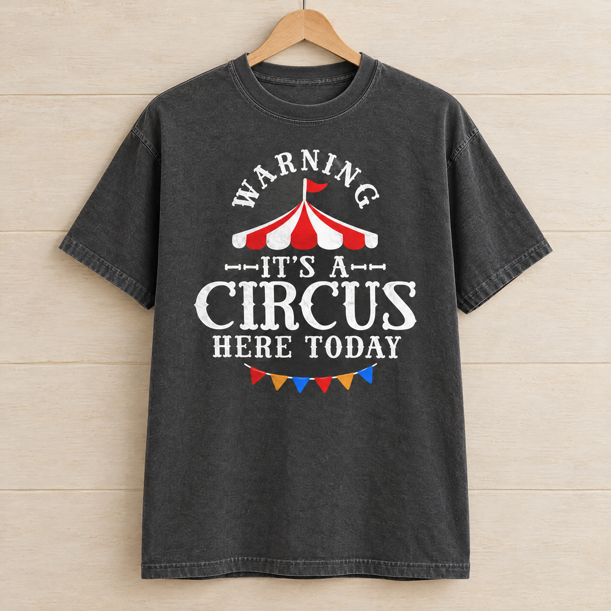 Warning It's A Circus Here Today shirt in Pepper Comfort Colors, on a wooden hanger