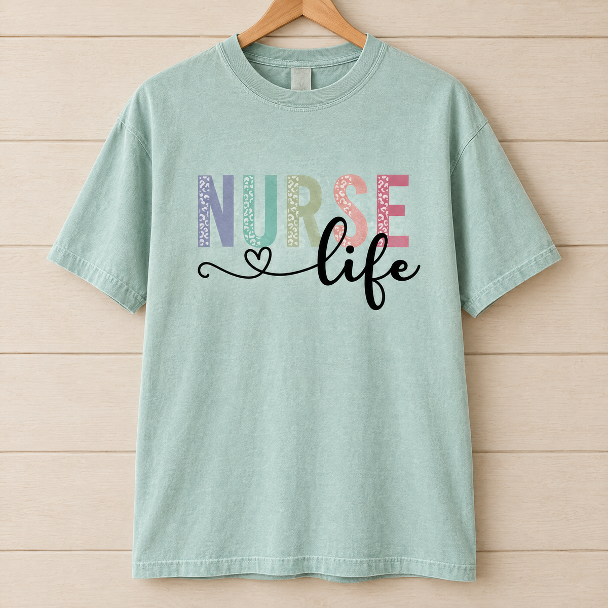 Nurse Life shirt in Seafoam Comfort Colors, on a wooden hanger