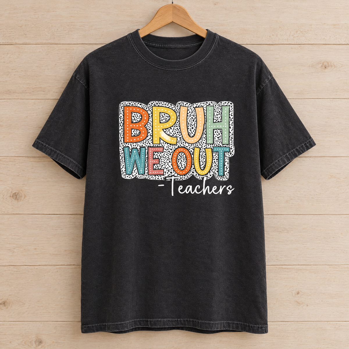 Bruh We Out Teachers shirt in Black Comfort Colors, on a wooden hanger
