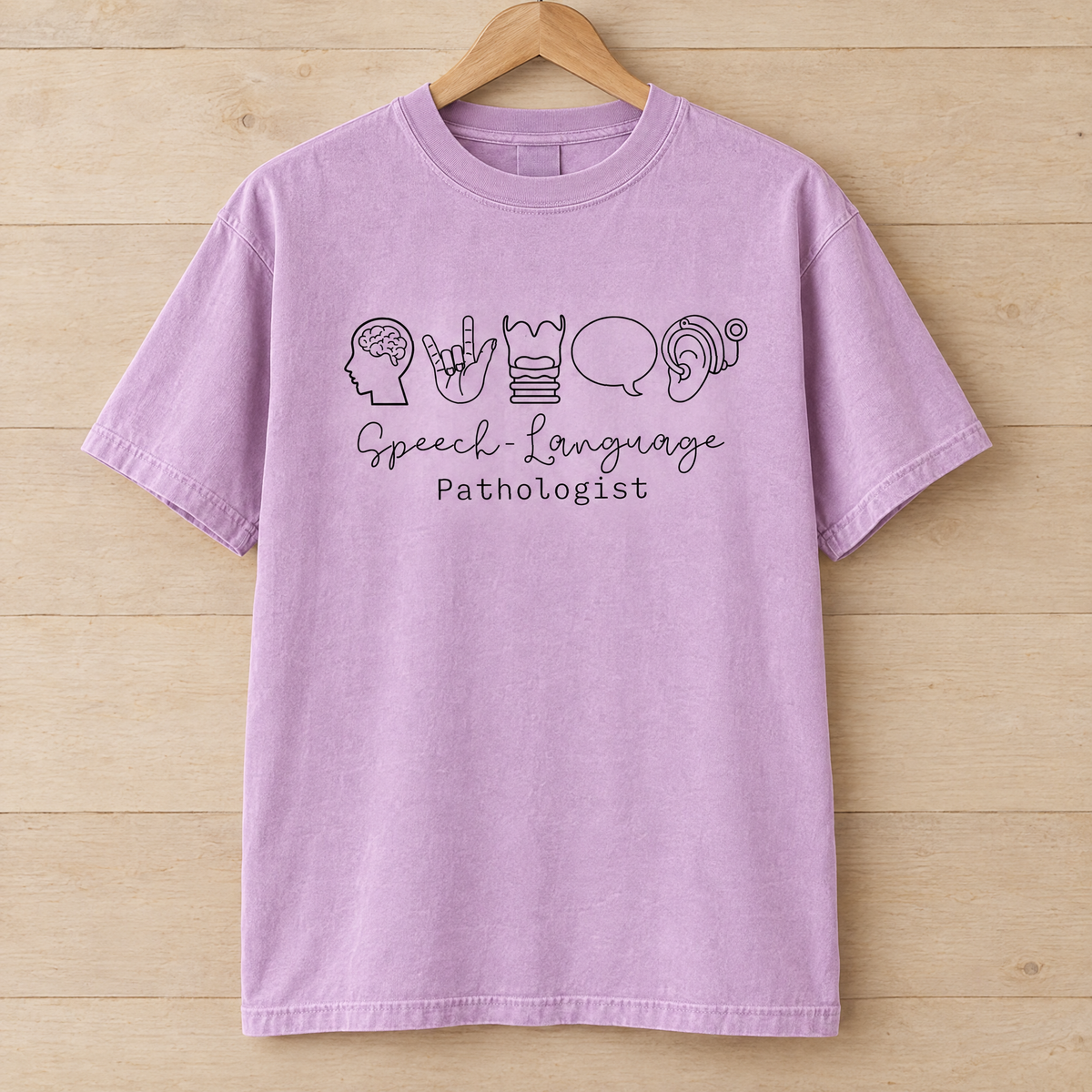 Speech Language Pathologist shirt in Orchid Comfort Colors, on a wooden hanger