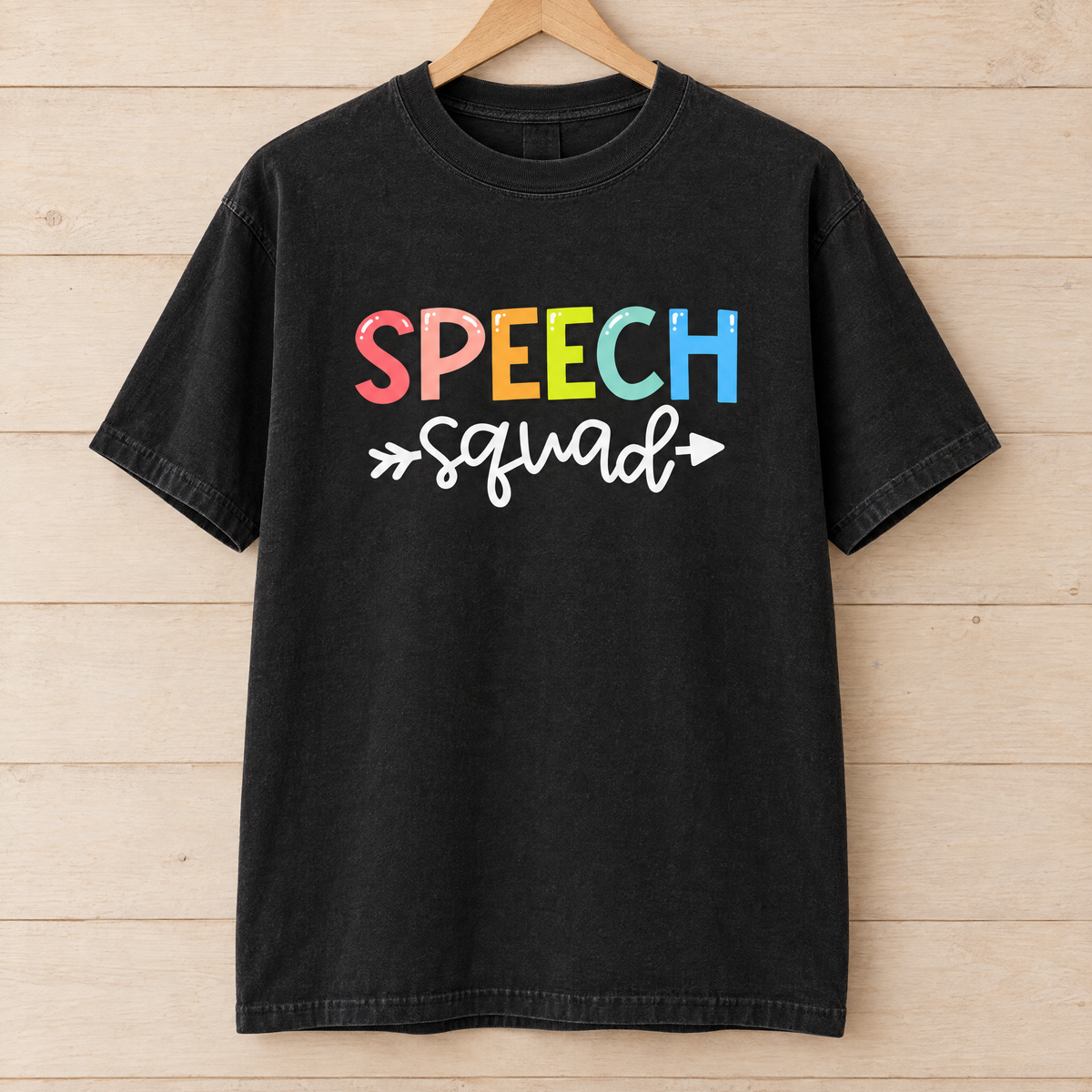Speech Squad shirt in Black Comfort Colors, on a wooden hanger