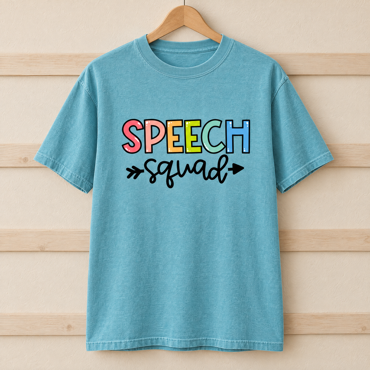 Speech Squad shirt in Lagoon Blue Comfort Colors, on a wooden hanger