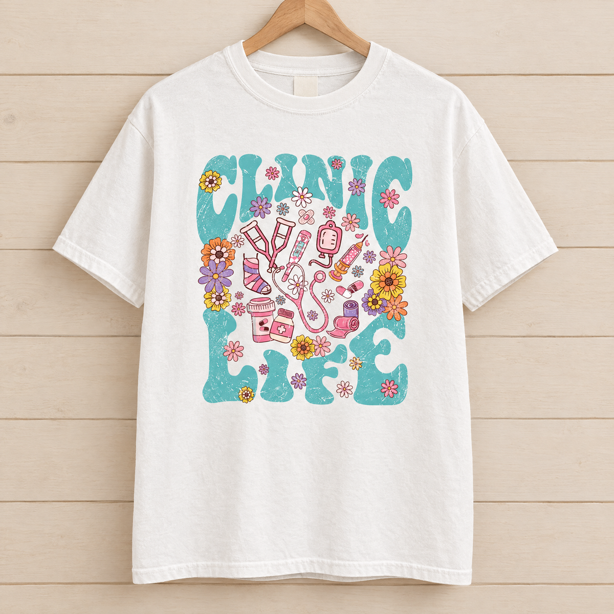 Clinic Life shirt in White Comfort Colors, on a wooden hanger