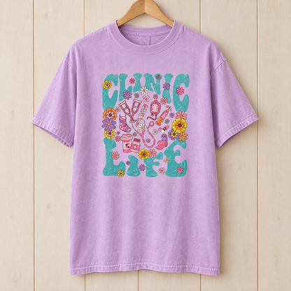 Clinic Life shirt in Orchid Comfort Colors, on a wooden hanger