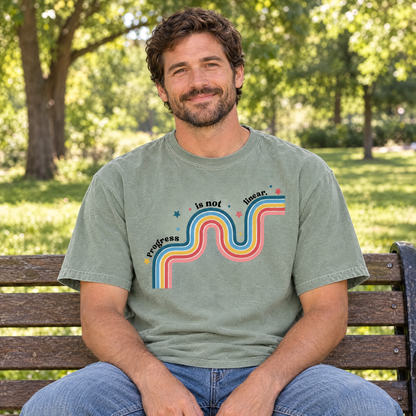 Progress Is Not Linear shirt in Sage Comfort Colors, worn by a seated model