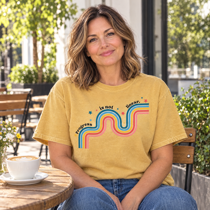 Progress Is Not Linear shirt in Mustard Comfort Colors, worn by a seated model