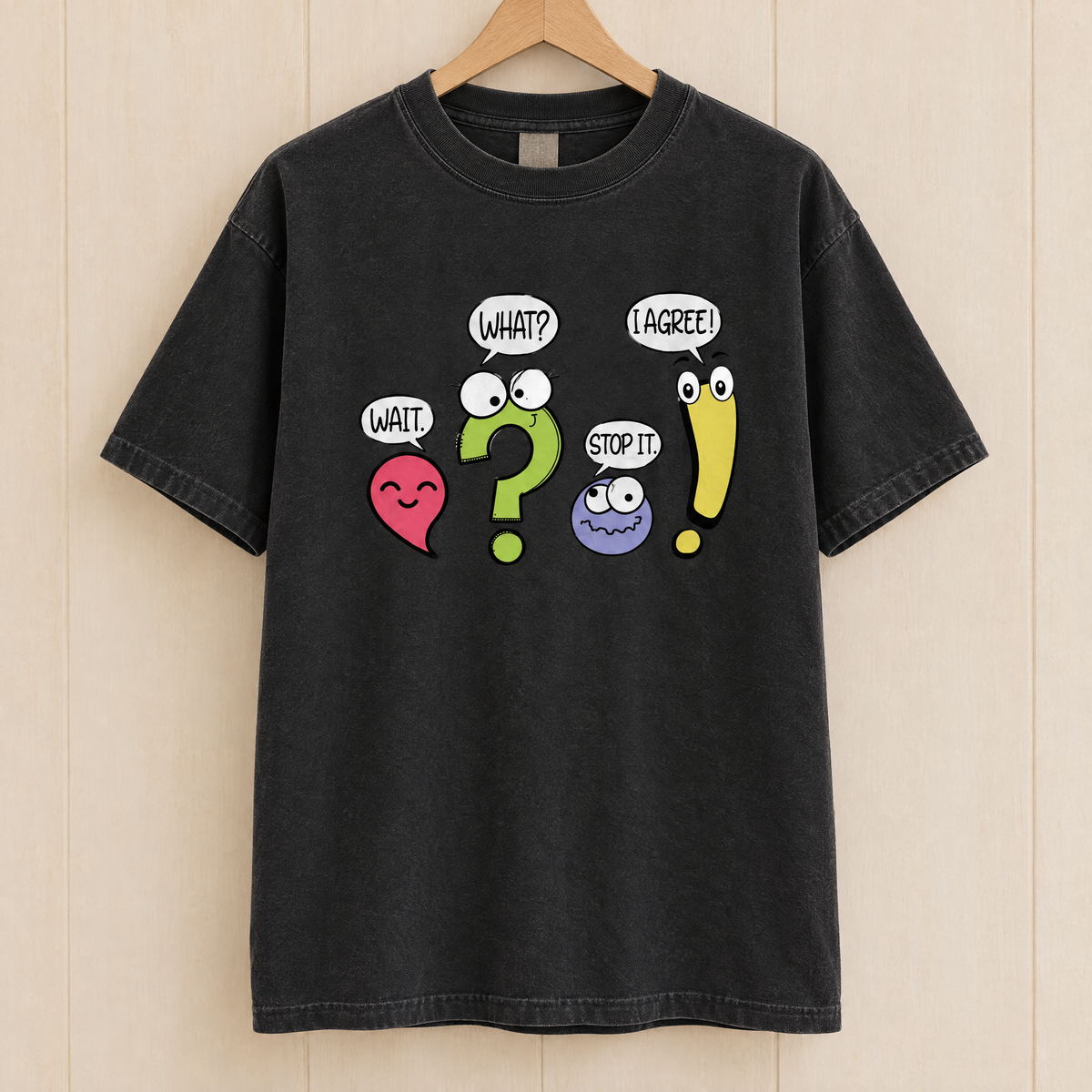 Punctuation shirt in Black Comfort Colors, on a wooden hanger