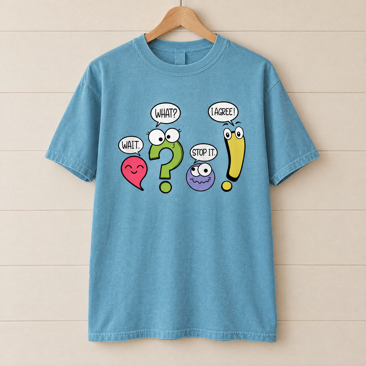 Punctuation shirt in Lagoon Blue Comfort Colors, on a wooden hanger