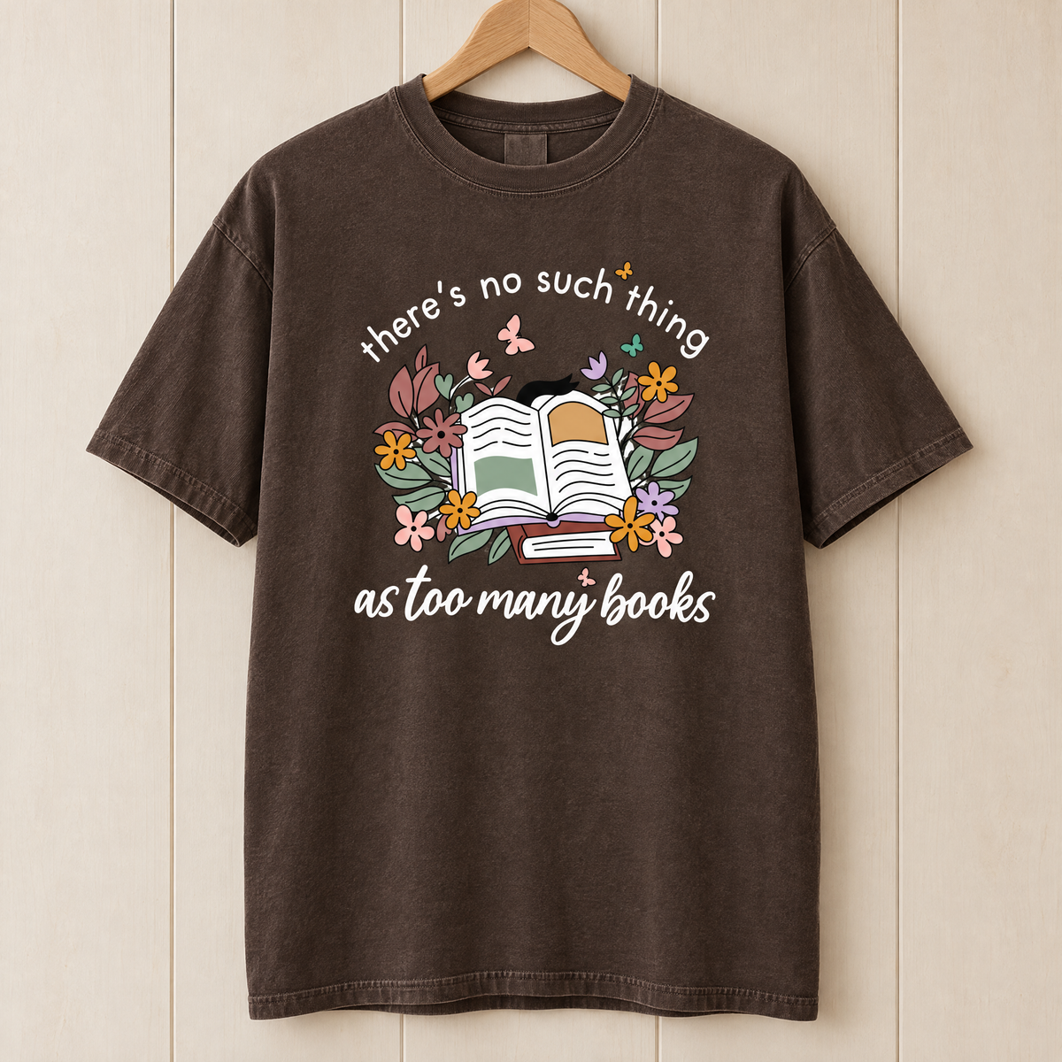 Too Many Books shirt in Espresso Comfort Colors, on a wooden hanger