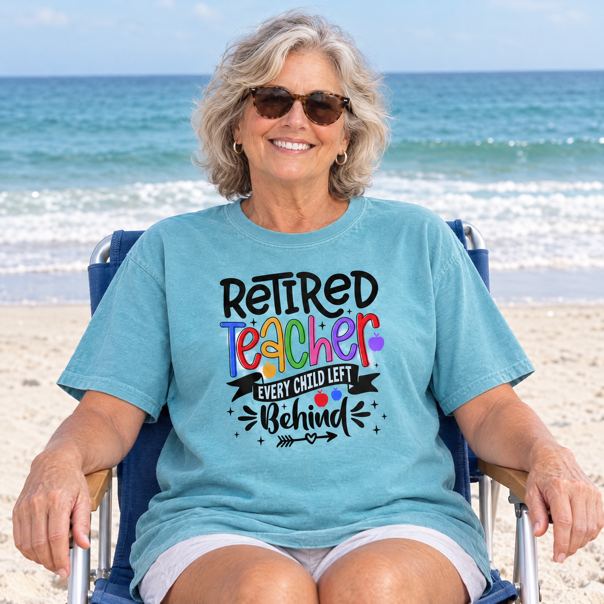 Retired Teacher shirt in Lagoon Blue Comfort Colors, worn by a seated model