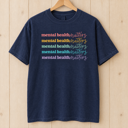 Mental Health Matters rainbow shirt in Midnight Comfort Colors on a wooden hanger