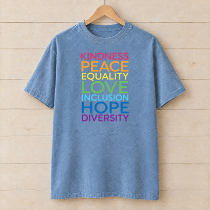 Kindness Peace Equality Love rainbow words shirt in Chambray Comfort Colors on a wooden hanger