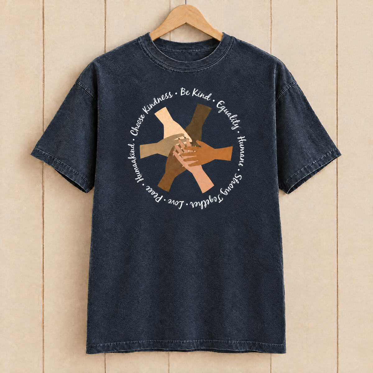 Choose Kindness diverse hands circle shirt in Midnight Comfort Colors on a wooden hanger