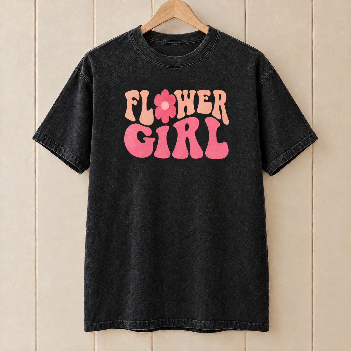 Flower Girl retro groovy shirt in Black Comfort Colors on a wooden hanger