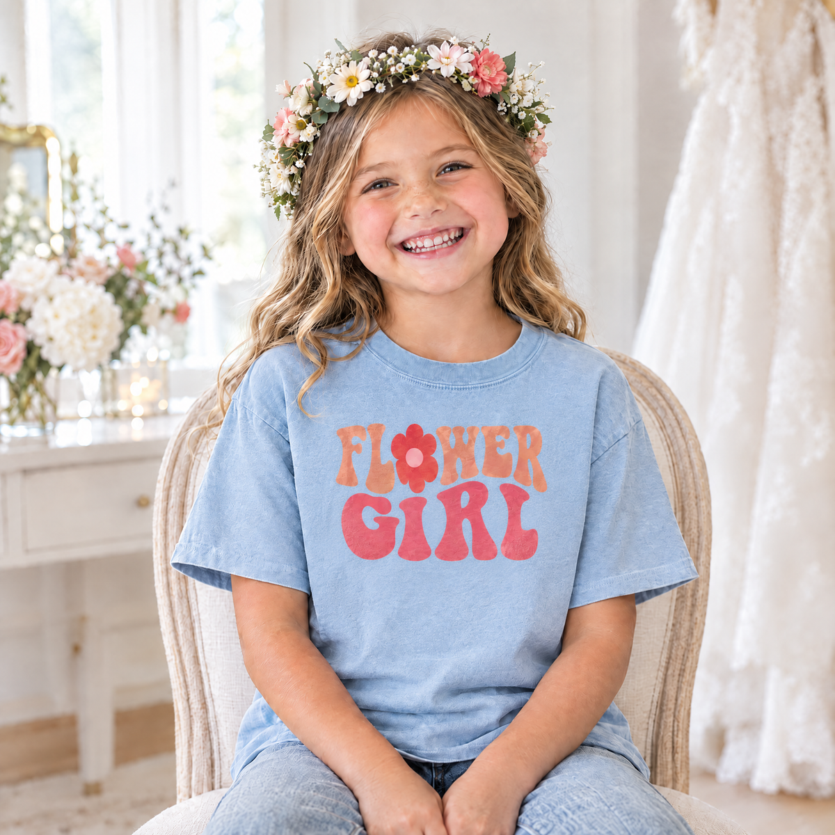Flower Girl retro groovy shirt in Chambray Comfort Colors, little girl with a flower crown sitting in a bridal getting-ready room