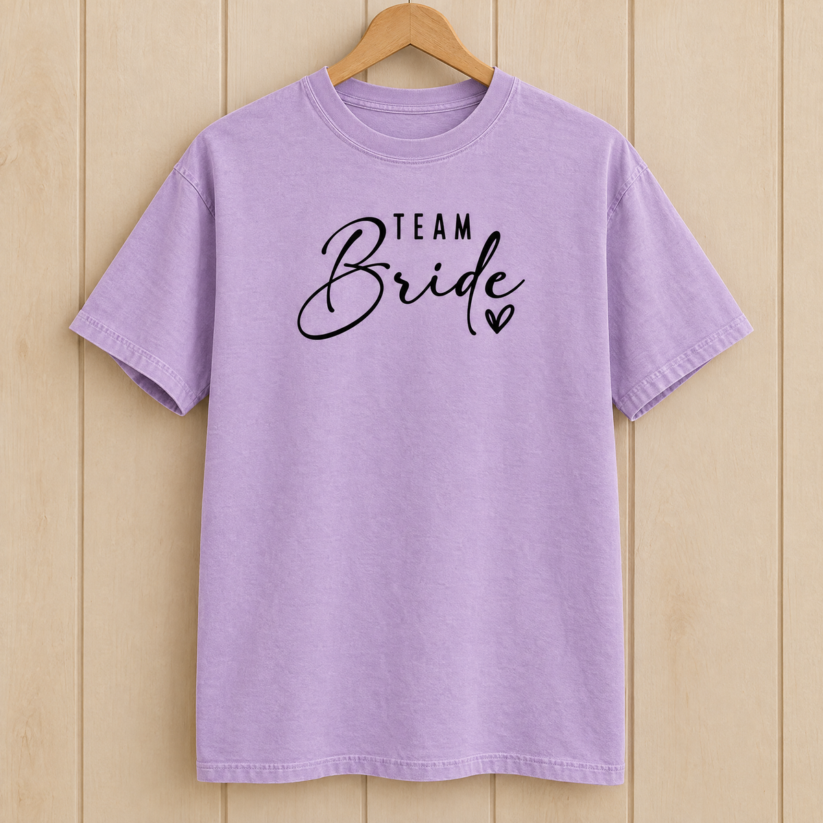 Team Bride shirt in Orchid Comfort Colors on a wooden hanger