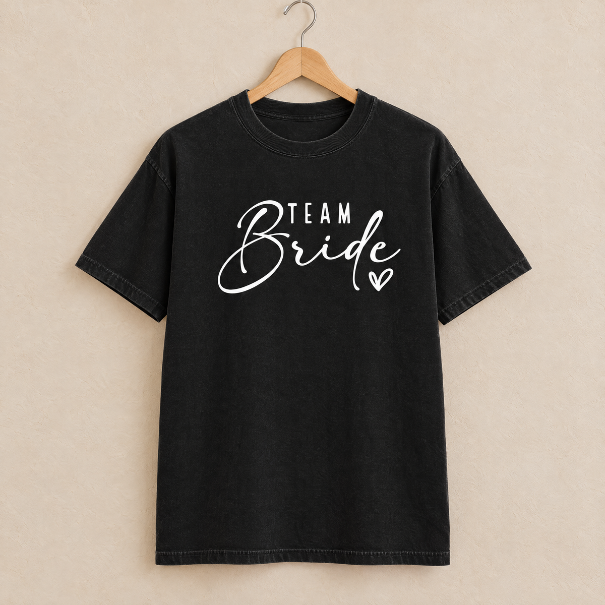 Team Bride shirt in Black Comfort Colors on a wooden hanger