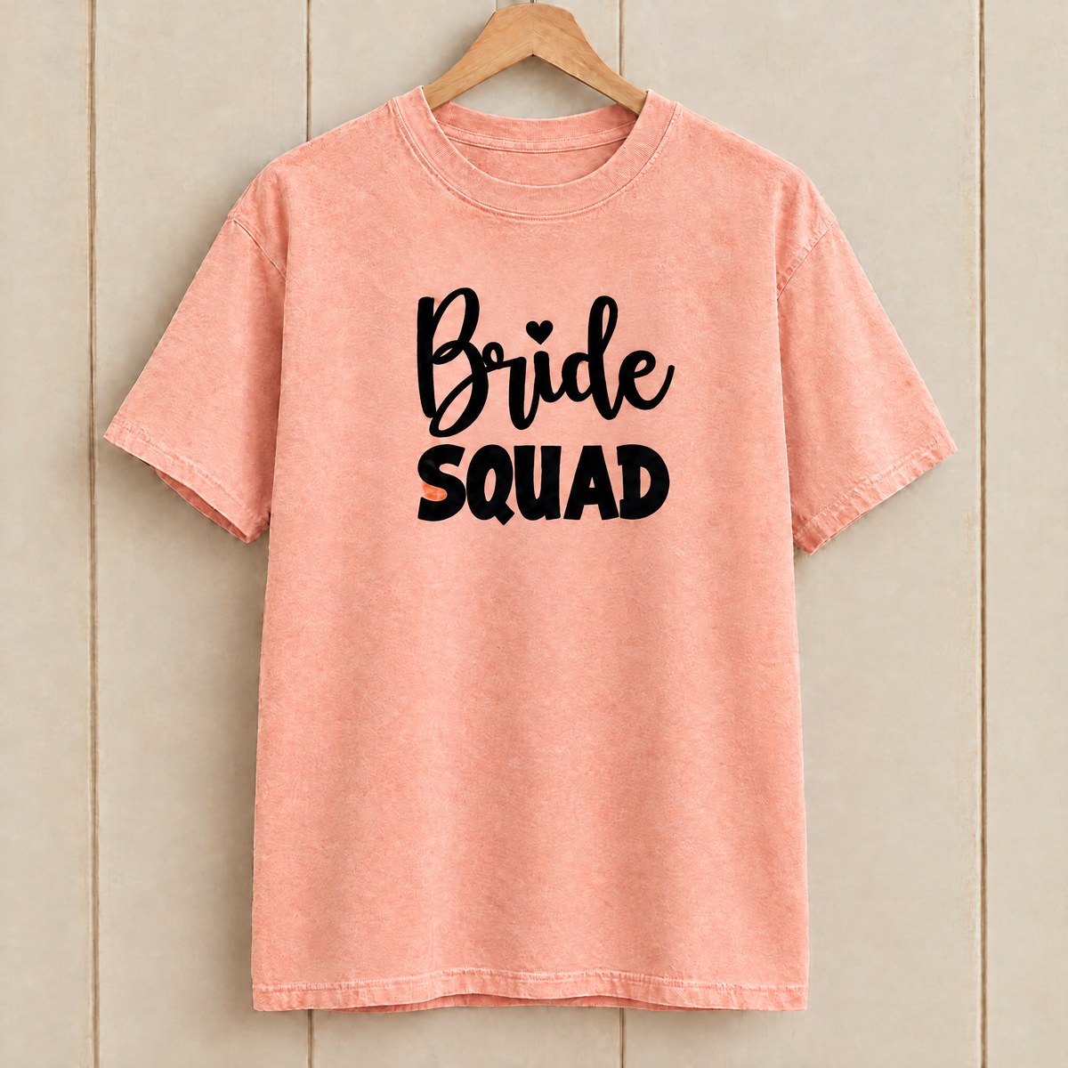 Bride Squad shirt in Peachy Comfort Colors on a wooden hanger