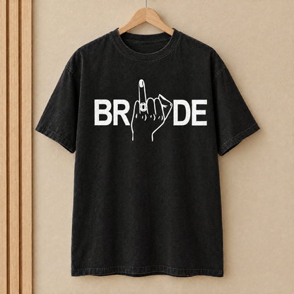 Bride shirt in Black Comfort Colors with white print on a wooden hanger