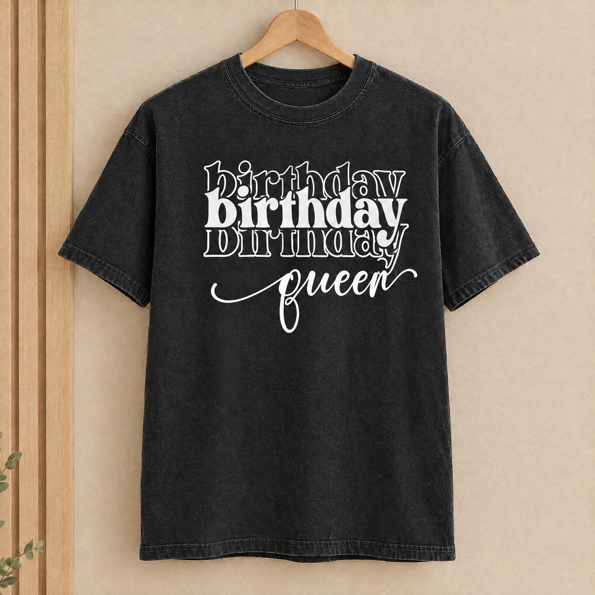 Birthday Queen shirt in Black Comfort Colors with white print on a wooden hanger