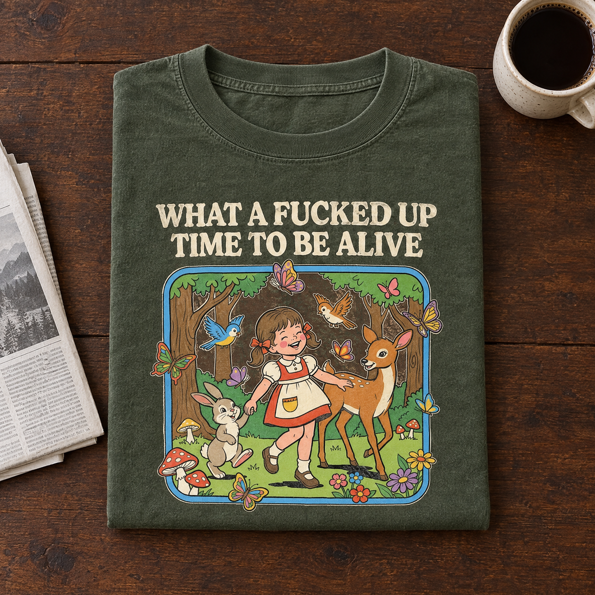 Funny dark humor tee in Moss, folded with a newspaper and black coffee
