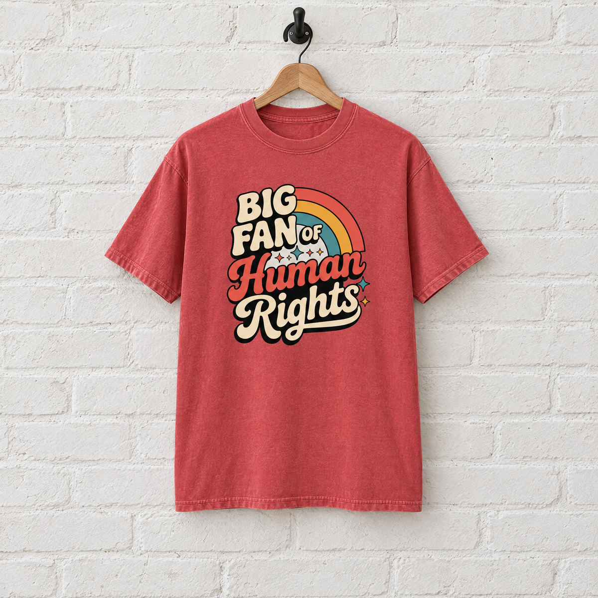 Big Fan of Human Rights Comfort Colors shirt in Red on a hanger against a white brick wall