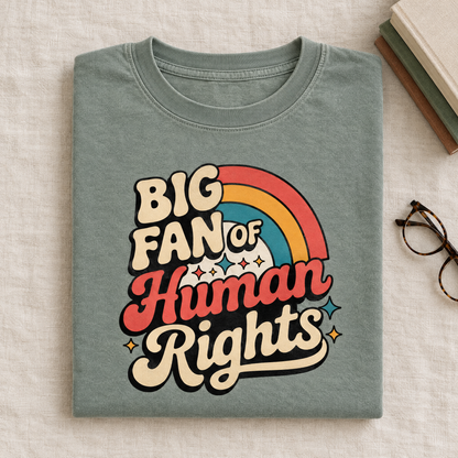 Social justice rainbow tee in Sage, folded with books and glasses