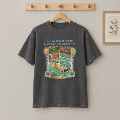 Pepper grey Learning About Lettuce shirt hanging on a wooden peg rail