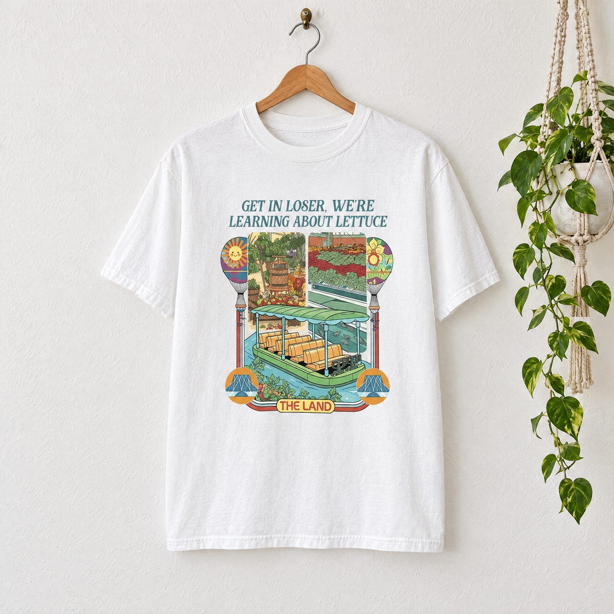 White Learning About Lettuce retro garden shirt on a hanger next to a hanging plant