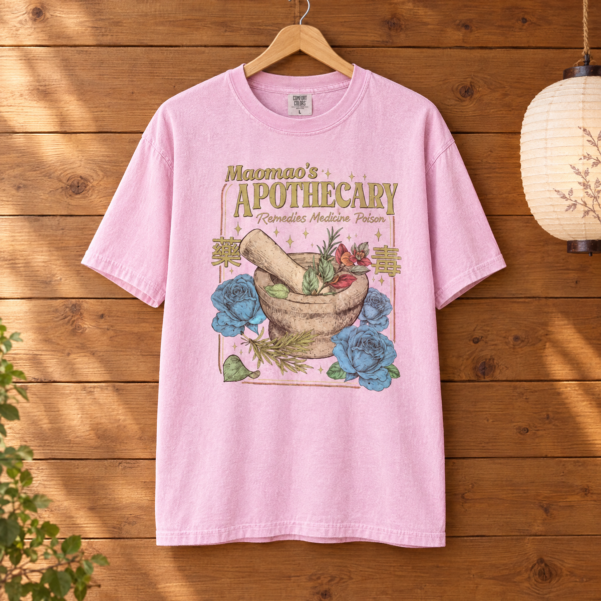Maomao's Apothecary Comfort Colors shirt in Blossom pink on a wooden hanger