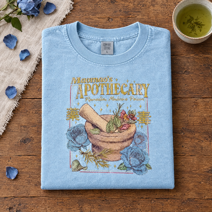 Anime herbal potion tee in Chambray, folded with green tea and blue rose petals
