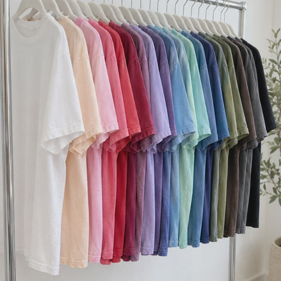 Comfort Colors t-shirts in many colors on a rack and folded in a stack